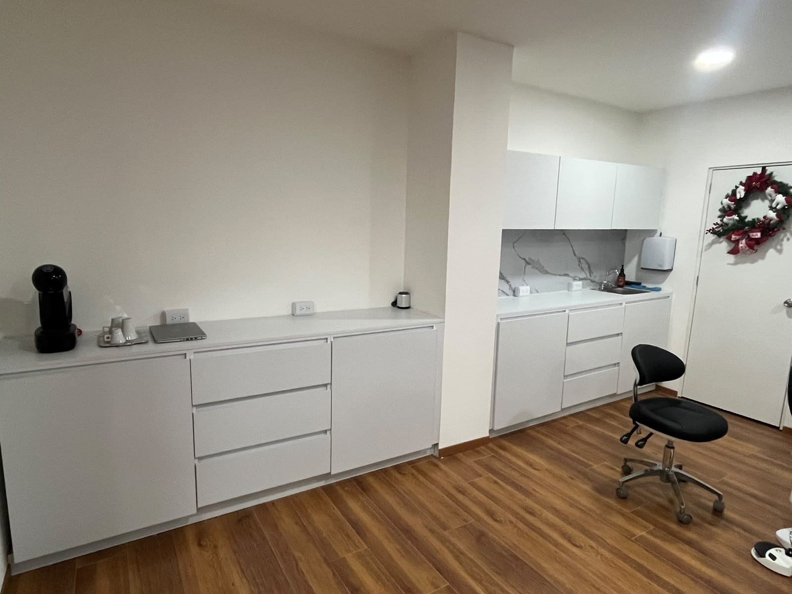 Mobiliario blanco a la medida con cubierta y cocineta para consultorio dental